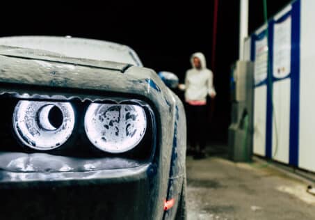 En bild på en person som tvättar en bil